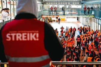 "Streik" steht auf der orangen Warnweste eines Streikenden: Mit Trillerpfeifen ziehen sie am Montagmorgen durch den Hamburger Hauptbahnhof.