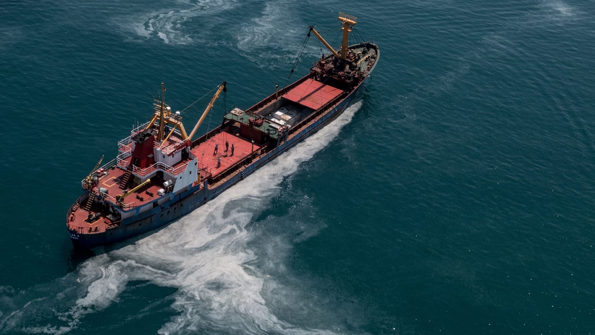 Ein Frachtschiff fährt übers Meer: Das Wasser der Ozeane erscheint immer grüner.