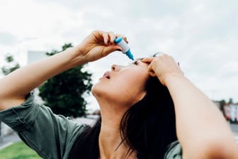 Eine junge Frau nutzt Augentropfen (Symbolbild): In den USA sind drei Menschen im Zusammenhang mit einem solchen Arzneimittel gestorben.