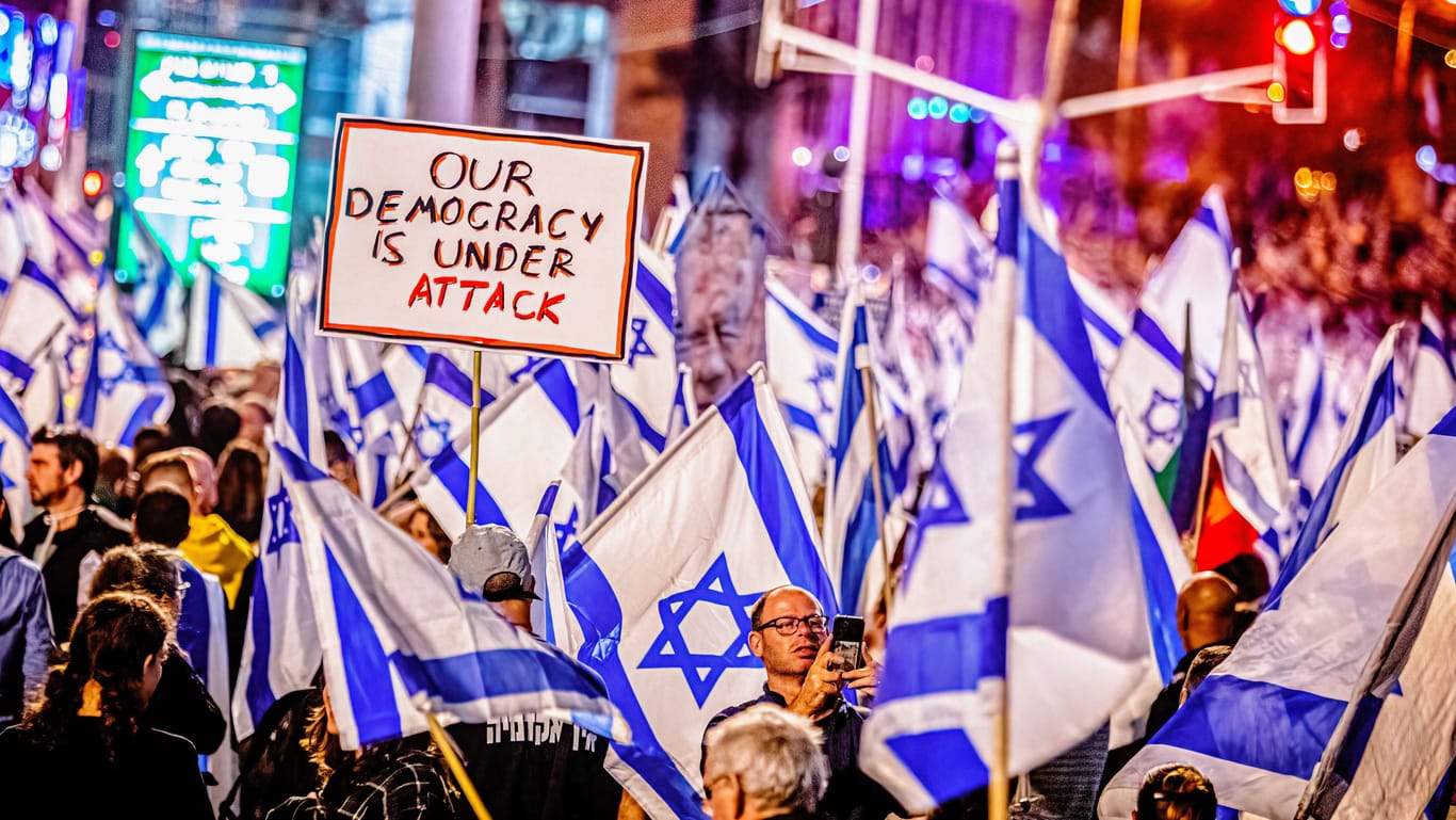 Proteste in Tel Aviv: Auf einem Plakat der Demonstrierenden steht "Unsere Demokratie wird attackiert".