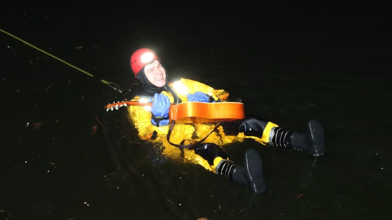 Ein Feuerwehrmann fischt die Gitarre aus dem Landwehrkanal: Der Besitzer hatte um die Bergung gebeten. Ein Feuerwehrmann fischt die Gitarre aus dem Landwehrkanal: Der Besitzer hatte um die Bergung gebeten.