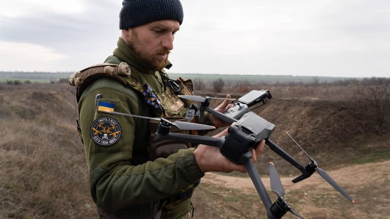 Ein ukrainischer Soldat hält eine Drohne in der Hand (Archivbild). In Zukunft sollen ganze Schwärme Angriffe auf russische Einheiten fliegen.