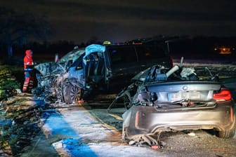 Zwei Fahrzeugwracks stehen auf einer Straße nahe Karlsruhe: Bei der Kollision eines Autos und eines Großraumtaxis nahe Karlsruhe starben fünf Menschen.