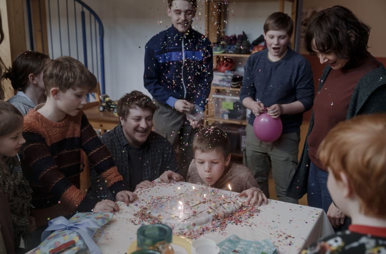 Im Frühstücksraum des Kinderheimes gibt es ein Geburtstagsständchen. Ronny (Johann Barnstorf) bläst die Kerzen auf seiner Geburtstagstorte aus.