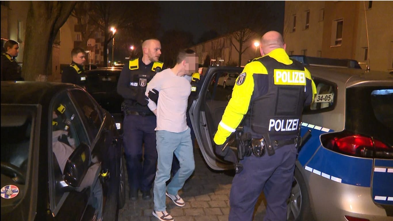 Ein Tatverdächtiger wird in Berlin-Lichtenberg abgeführt: Der Mann soll nach dem Angriff seine Wohnung verlassen haben, um sich in einer Kneipe ein paar Bier zu holen.
