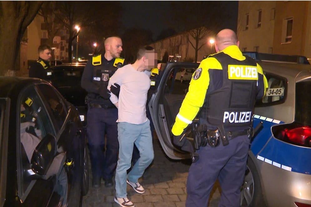 Ein Tatverdächtiger wird in Berlin-Lichtenberg abgeführt: Der Mann soll nach dem Angriff seine Wohnung verlassen haben, um sich in einer Kneipe ein paar Bier zu holen.