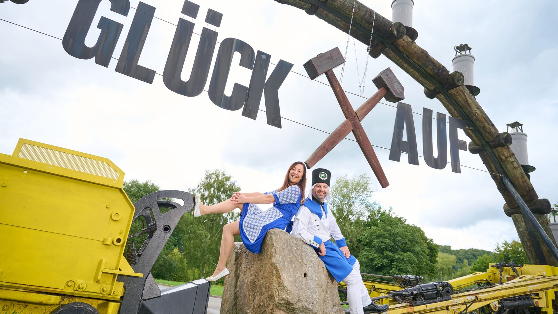 Durch den Tag der Sachsen sollen die Bürger von Aue-Bad Schlema zusammenwachsen. Passend dazu gibt es zwei Symbolfiguren. Keine Maskottchen, sondern ein Bademädchen und einen Blaufarbenwerker aus Fleisch und Blut. Zusammen versinnbildlichen sie die historischen Merkmale der Region.