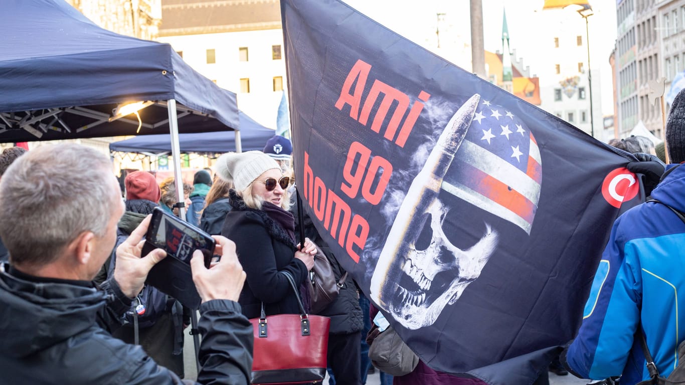 Amerikafeindliche Flagge bei einer Demonstration in München (Symbolbild): Dort nahmen auch Rechtsextreme teil, von denen es in Bayern weiter viele gibt.