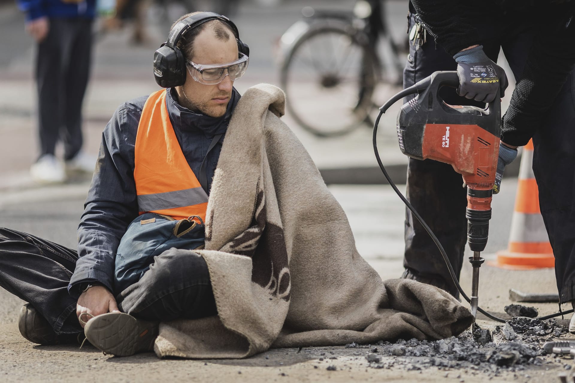 Ein Aktivist der Protestbewegung 'Letzte Generation', wird mit einer Schlagbohrmaschine in Berlin von der Straße entfernt.