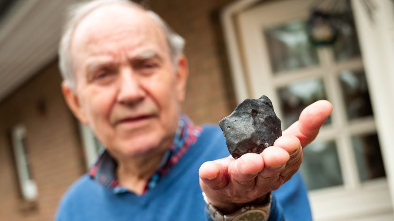 Wilfried Labusch, Hausbesitzer, hält vor seinem Haus einen kleinen Meteoriten: Das Allgestein hat sein Dach durchschlagen.
