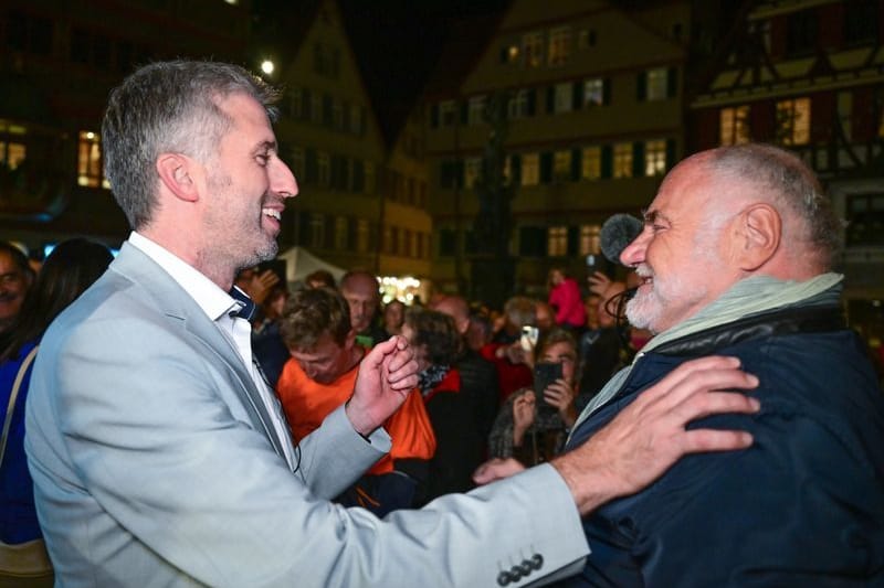 ARCHIV - 23.10.2022, Baden-Württemberg, Tübingen: Boris Palmer (l), der alte und neue Oberbürgermeister von Tübingen, bekommt nach seiner Wiederwahl auf dem Marktplatz Glückwünsche von Rezzo Schlauch. (zu dpa: «Anwalt Rezzo Schlauch wendet sich von Boris Palmer ab») Foto: Bernd Weißbrod/dpa +++ dpa-Bildfunk +++