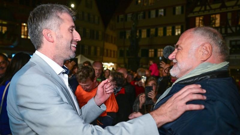 ARCHIV - 23.10.2022, Baden-Württemberg, Tübingen: Boris Palmer (l), der alte und neue Oberbürgermeister von Tübingen, bekommt nach seiner Wiederwahl auf dem Marktplatz Glückwünsche von Rezzo Schlauch. (zu dpa: «Anwalt Rezzo Schlauch wendet sich von Boris Palmer ab») Foto: Bernd Weißbrod/dpa +++ dpa-Bildfunk +++