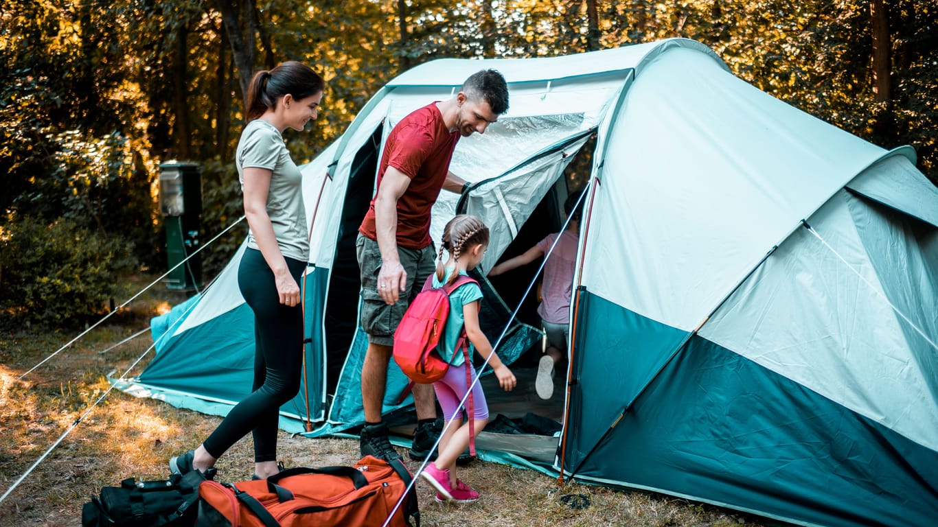 Eine Familie beim Camping: Bei Aldi sind Zelte und Campingausrüstung heute im Angebot (Symbolbild).