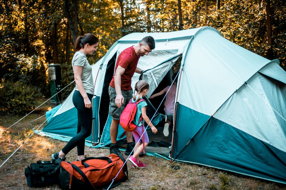 Eine Familie beim Camping: Bei Aldi sind Zelte und Campingausrüstung heute im Angebot (Symbolbild).