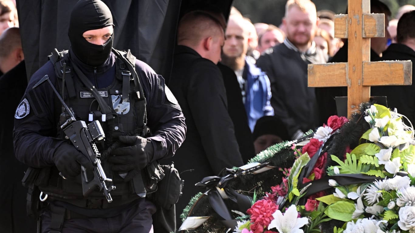 Schwer bewaffnete Sicherheitsleute sind auf einem Friedhof in St. Petersburg im Einsatz, wo der militante Blogger Maxim Fomin beerdigt wurde.