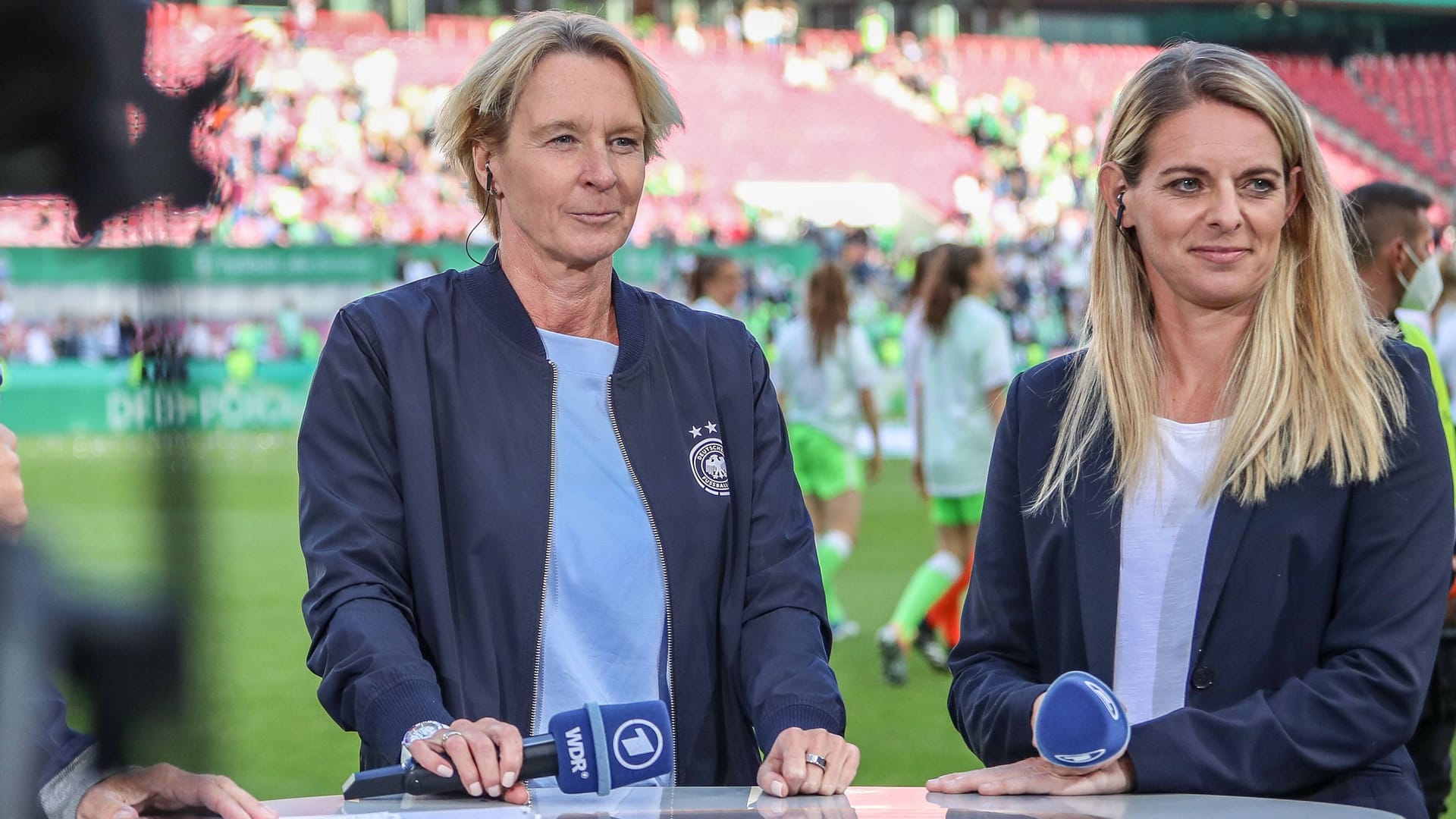 Bundestrainerin Martina Voss-Tecklenburg (l.) neben Nia Künzer: Noch immer wissen deutsche Fußballfans nicht, wo sie die WM im Sommer sehen können.