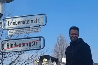 Aus Hindenburgstraße wird Loebensteinstraße: Bezirksbürgermeister Jannik Schnare (Grüne) enthüllt das neue Straßenschild.