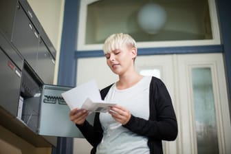 Eine Frau öffnet einen Brief (Symbolbild): Post vom Vermieter ist meist kein gutes Zeichen.