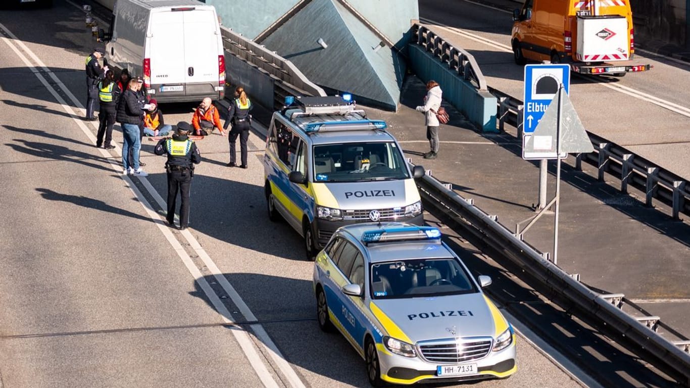Klimaaktivisten haben sich am Donnerstag auf der Fahrbahn der Autobahn 7 festgeklebt und so die Zufahrt des Elbtunnels in Richtung Norden blockiert.