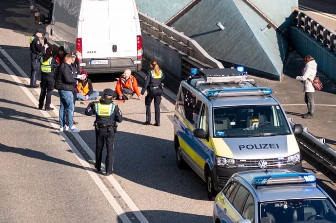 Klimaaktivisten haben sich am Donnerstag auf der Fahrbahn der Autobahn 7 festgeklebt und so die Zufahrt des Elbtunnels in Richtung Norden blockiert.