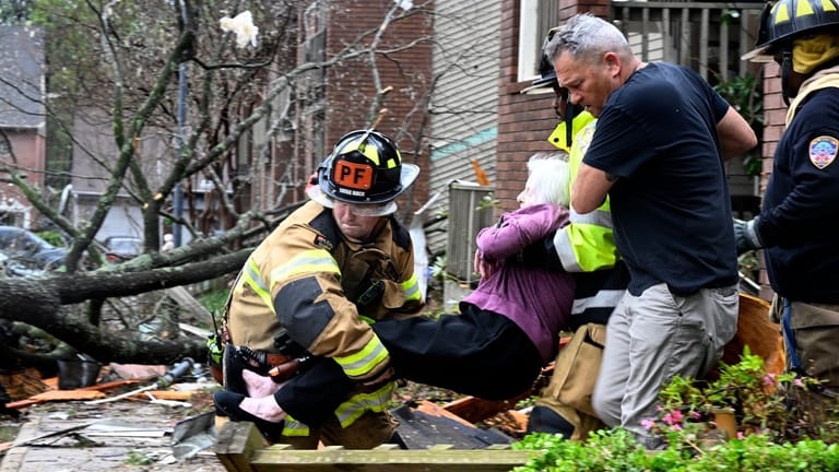 Feuerwehrleute tragen eine Frau aus ihrem zerstörten Haus: Örtliche Rettungsdienste gehen von bis zu 600 Verletzten in der betroffenen Region aus.