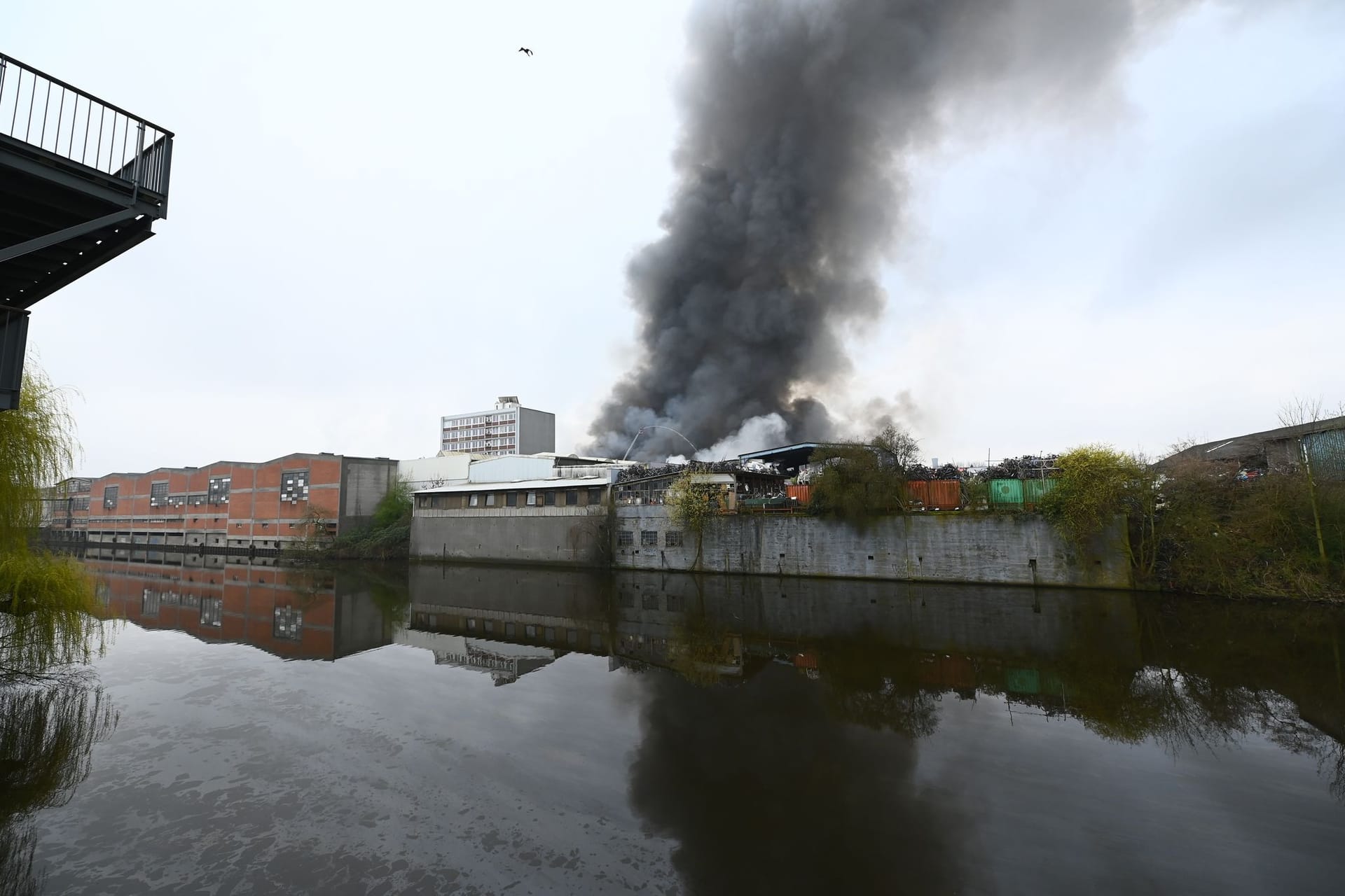 Eine dichte Rauchwolke steigt hinter dem Billekanal von brennenden Lagerhallen auf (Archivbild): Nach mehr als einer Woche wurde das Feuer gelöscht.