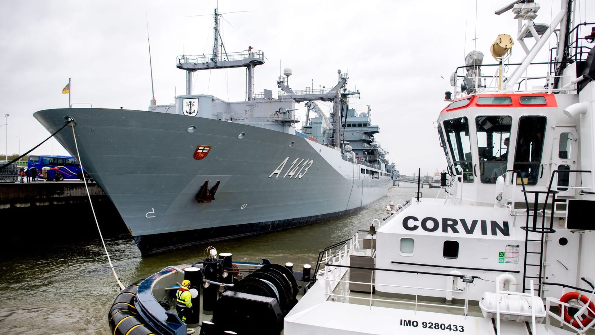 Der Schlepper "Corvin" verbindet kurz vor dem Ablegen eine Schleppleine mit dem Einsatzgruppenversorger "Bonn" im Hafen am Marinestützpunkt.