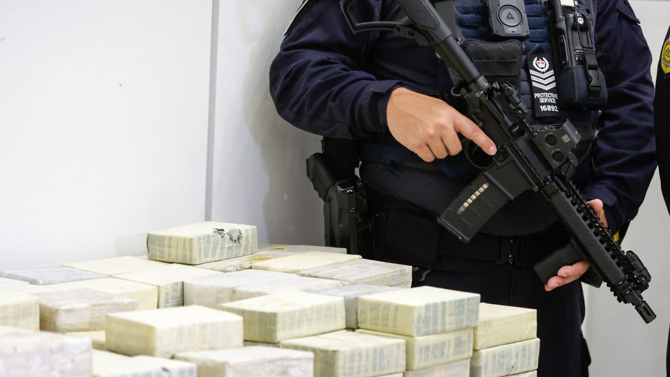 Ein Polizist bewacht die beschlagnahmten Drogenpäckchen in Queensland.