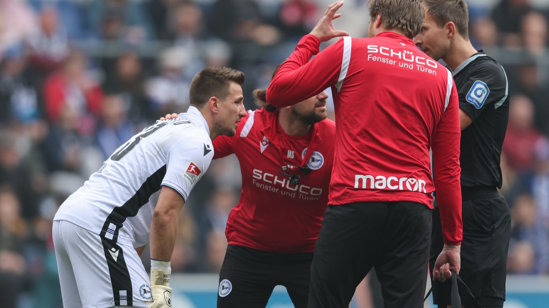 2. Bundesliga: Fans von Düsseldorf haben einen lauten Böller gezündet. Bielefelds Torwart Martin Fraisl (li.) wird darauf hin behandelt.