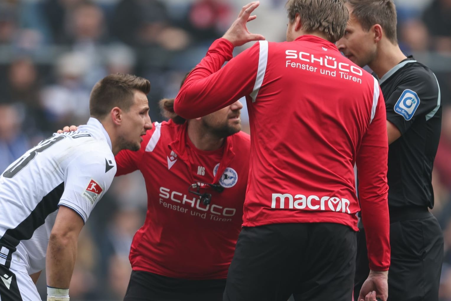 2. Bundesliga: Fans von Düsseldorf haben einen lauten Böller gezündet. Bielefelds Torwart Martin Fraisl (li.) wird darauf hin behandelt.