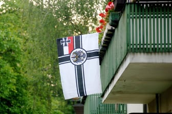 Eine Reichsflagge hängt an einem Balkon (Symbolbild): Völkische Siedler verhalten sich oft unauffällig.