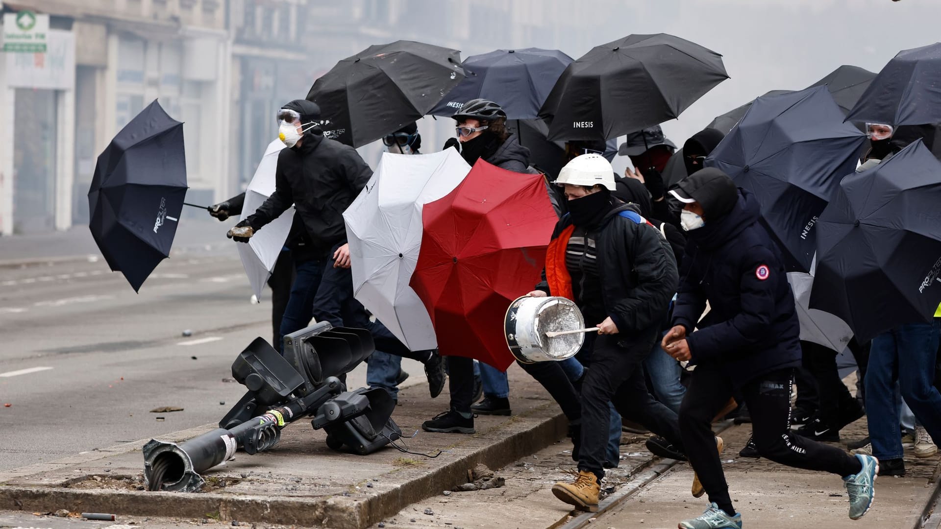 Proteste in Nantes: Demonstranten schützen sich mit Regenschirmen vor dem Tränengas der Polizei. Proteste in Nantes: Demonstranten schützen sich mit Regenschirmen vor dem Tränengas der Polizei.