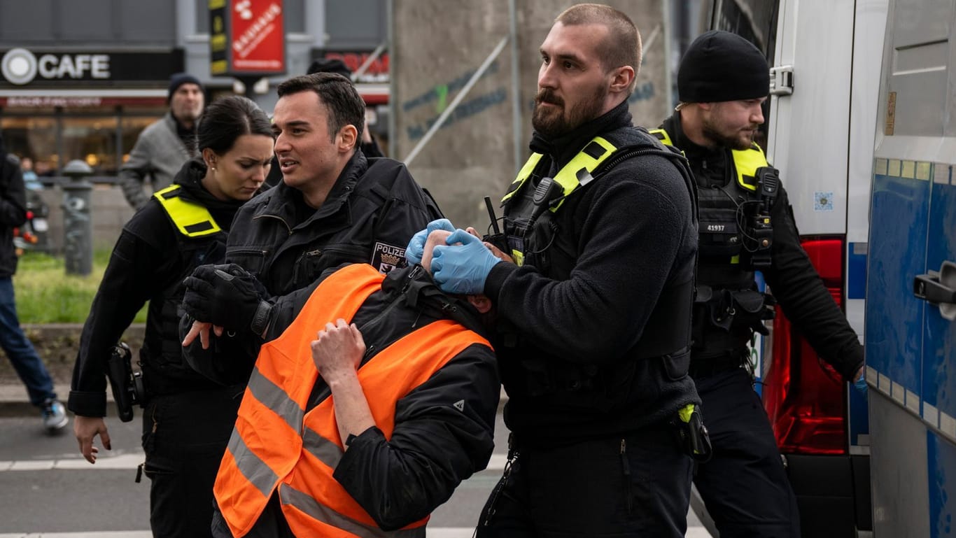Protest in Berlin: Ein Aktivist wird von zwei Polizisten abgeführt.