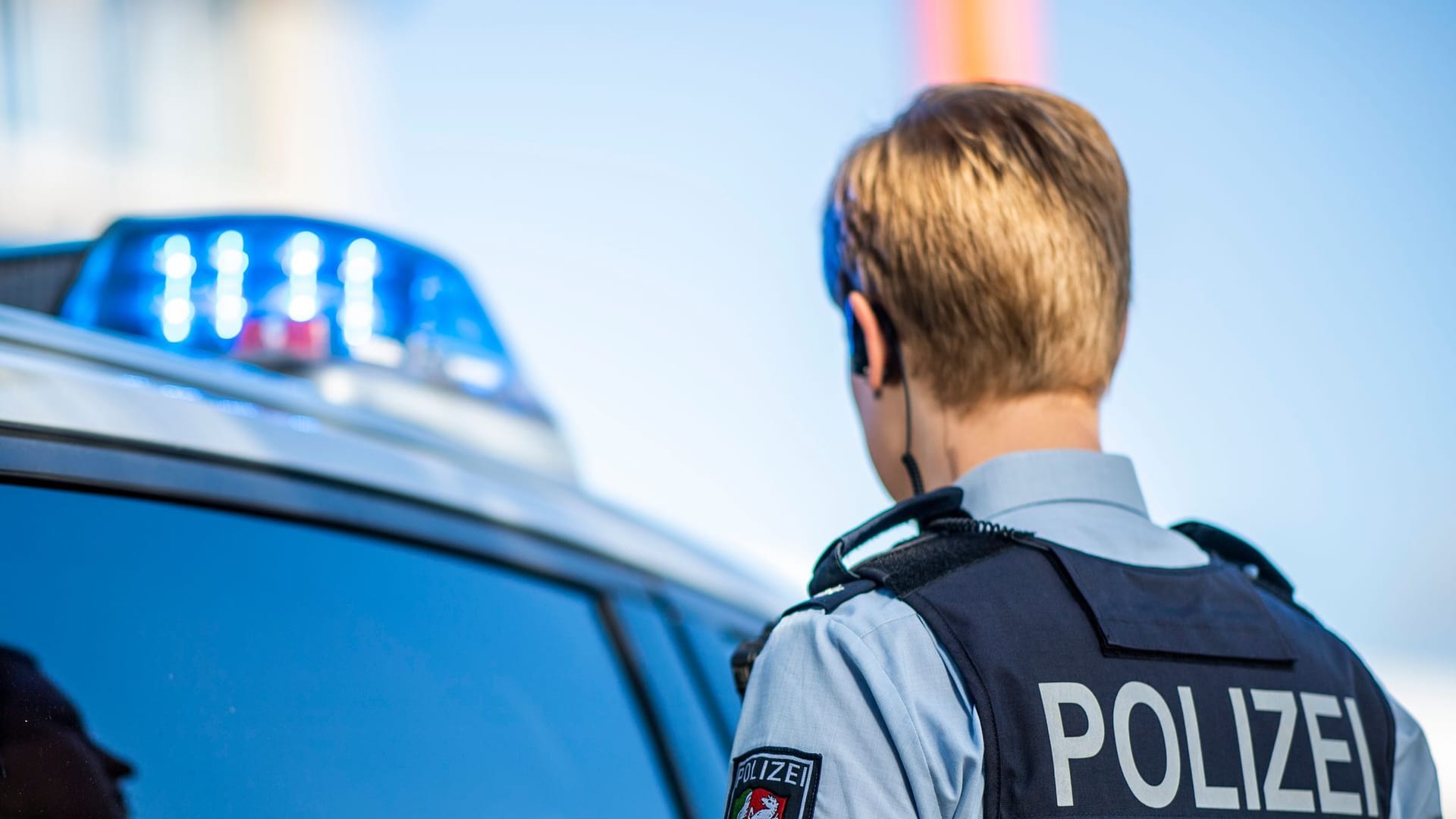 Polizistin neben Streifenwagen