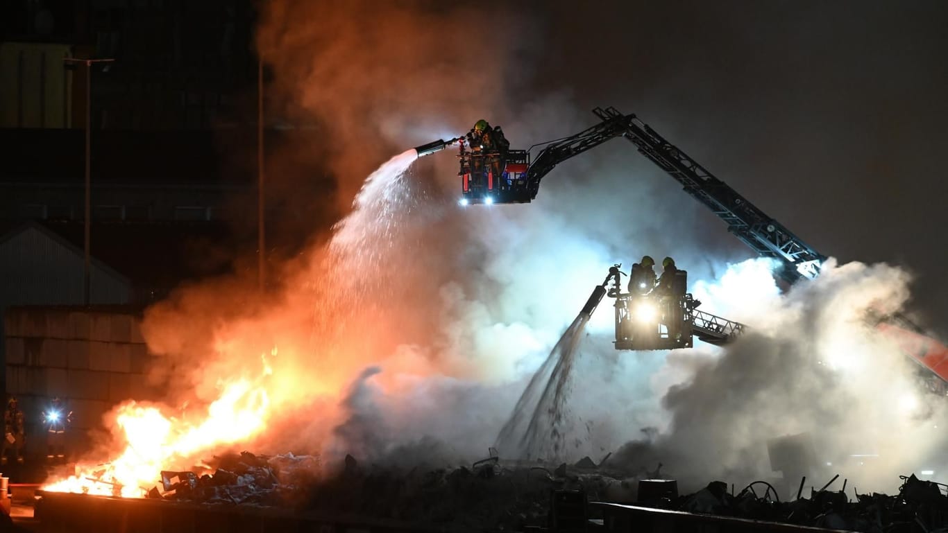 Einsatzkräfte der Berliner Feuerwehr löschen den Brand auf einem Lastschiff in Neukölln