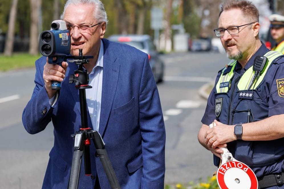 Blitzermarathon 2023: Innenminister Joachim Herrmann (links) schaut neben Hauptkommissar Dirk Klinge von der Verkehrspolizeiinspektion Nürnberg durch ein Laserhandmessgerät.