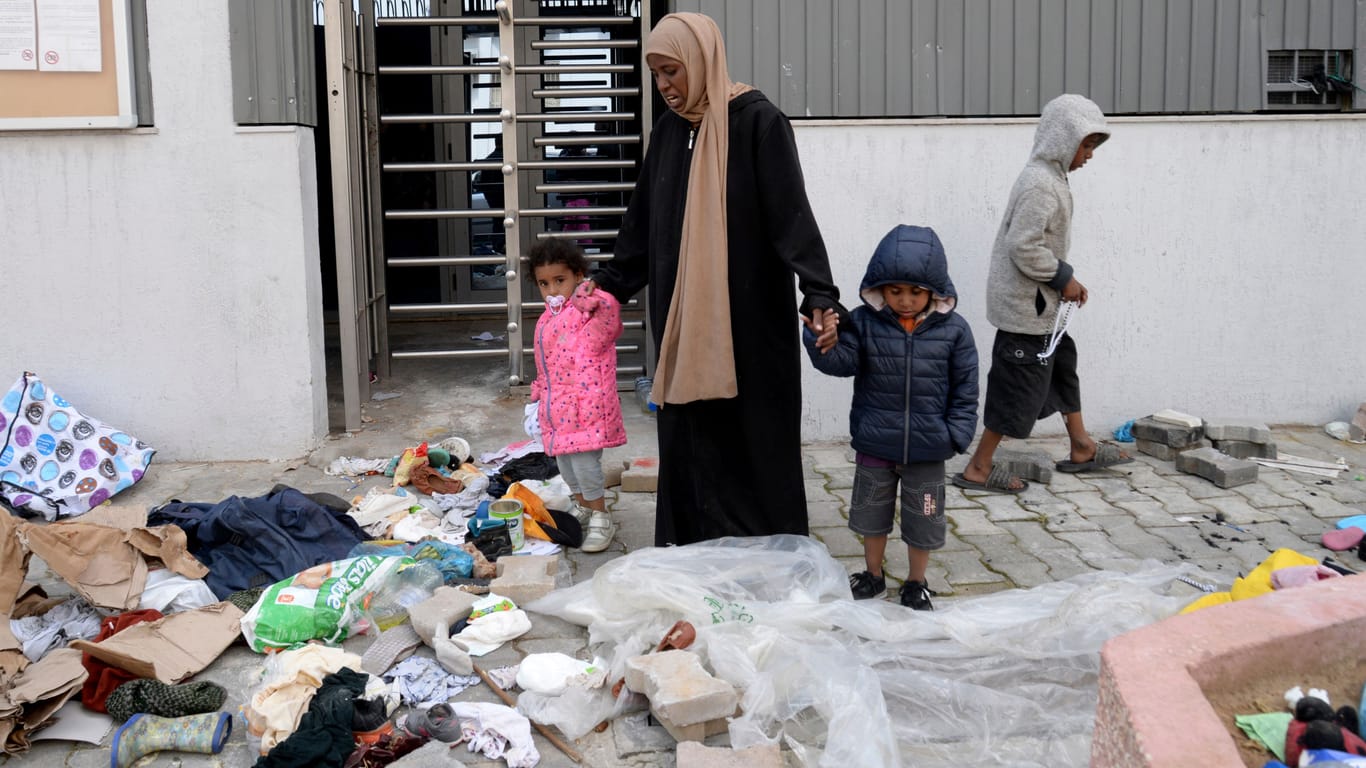 Eine Frau und ihre Kinder stehen bei ihren Habseligkeiten, nachdem tunesische Polizeikräfte ein provisorisches Lager geräumt haben: Die Situation für Migranten in dem nordafrikanischen Staat wird immer prekärer.