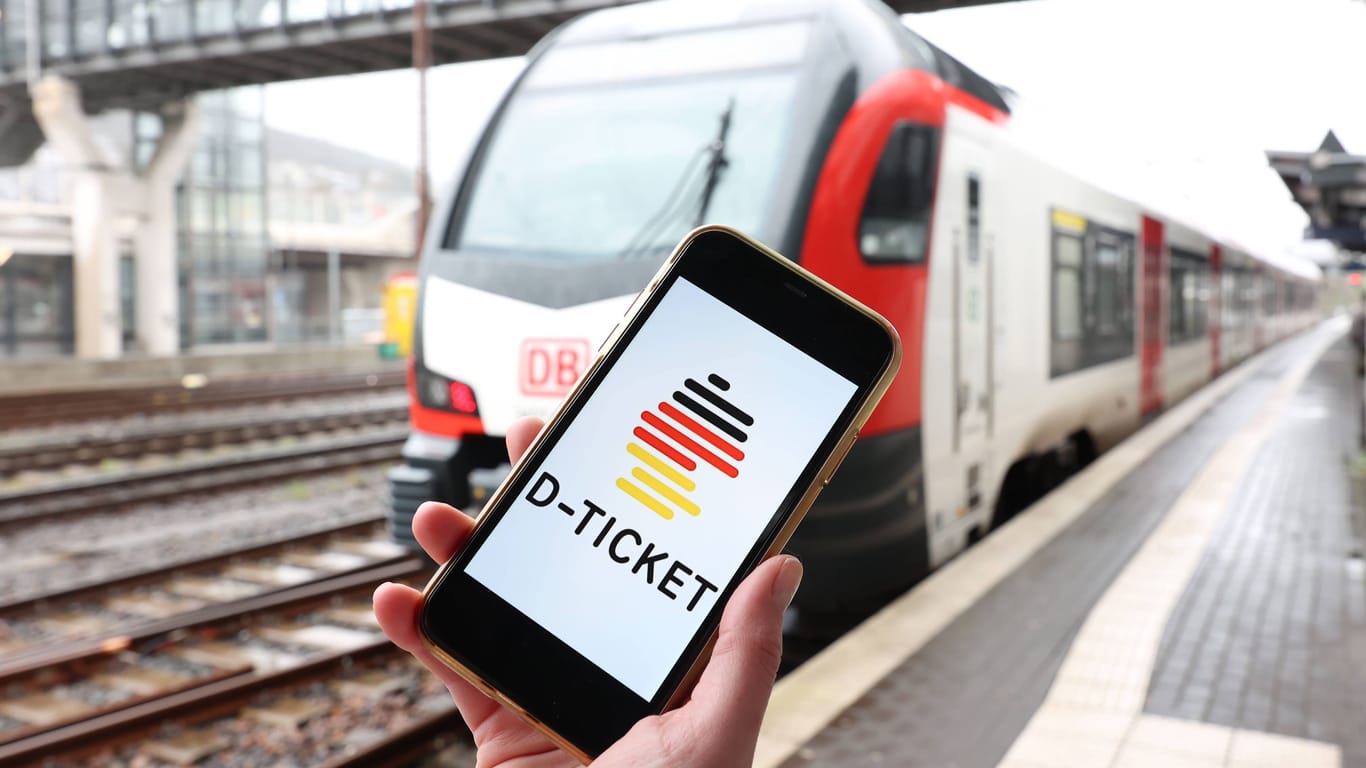 Ein Smartphone mit dem Deutschlandticket vor einem Zug (Symbolfoto): In Niedersachsen sind keine landesweiten Ermäßigungen zum Start des 49-Euro-Tickets angekündigt.