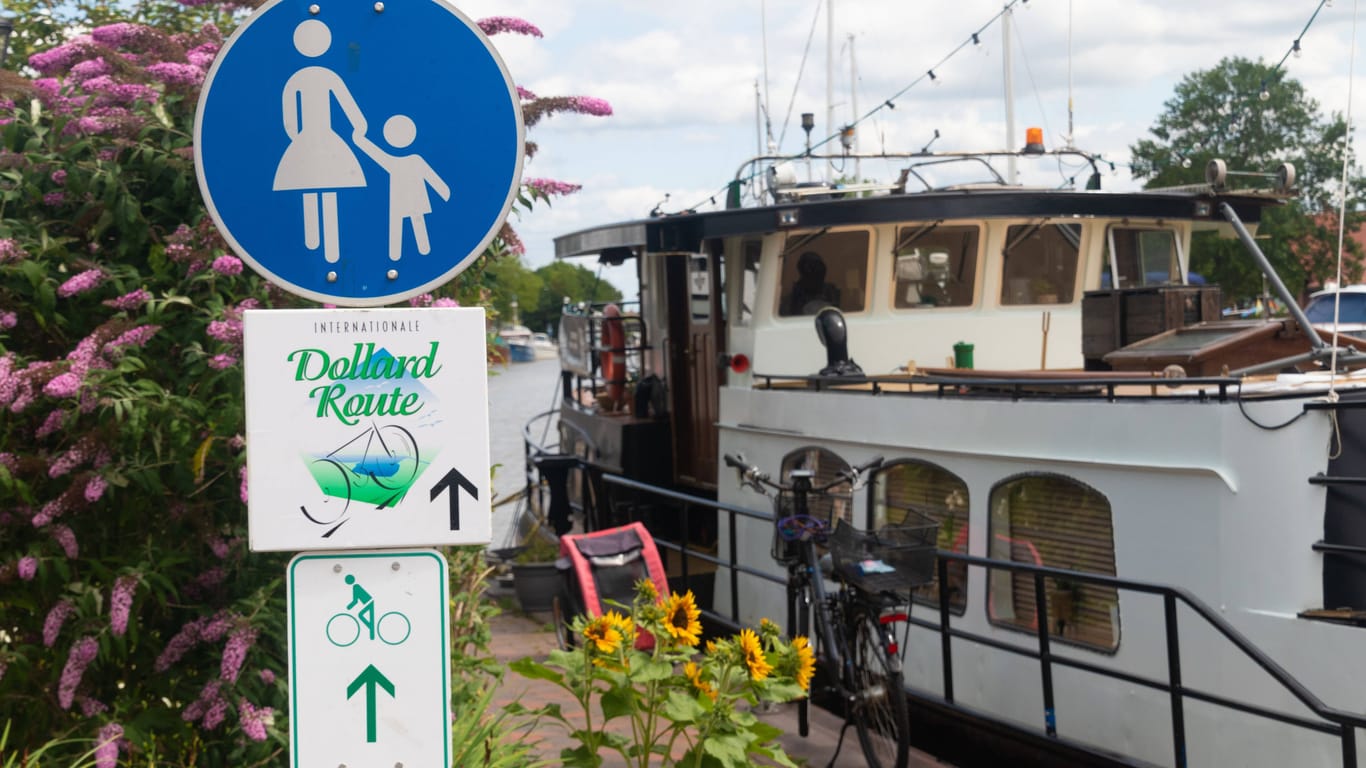 Der Fahrradweg Dollard Route geht an einem Schiff vorbei im historischen Hafen von Weener in Ostfriesland.