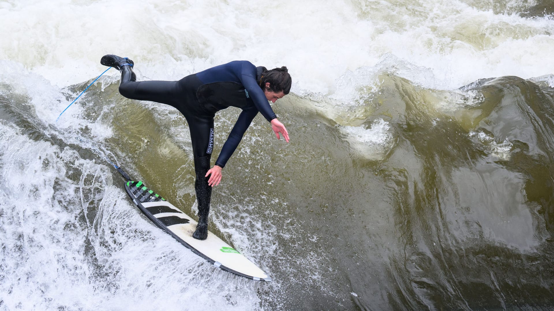 Ein Surfer testet die Leinewelle auf dem Fluss Leine in der Altstadt.