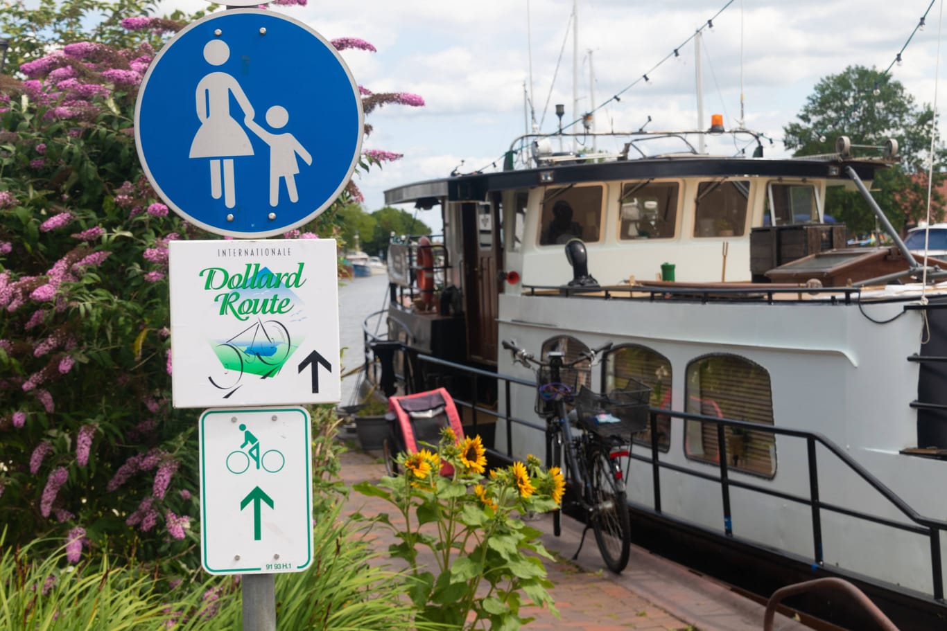 Der Fahrradweg Dollard Route geht an einem Schiff vorbei im historischen Hafen von Weener in Ostfriesland.
