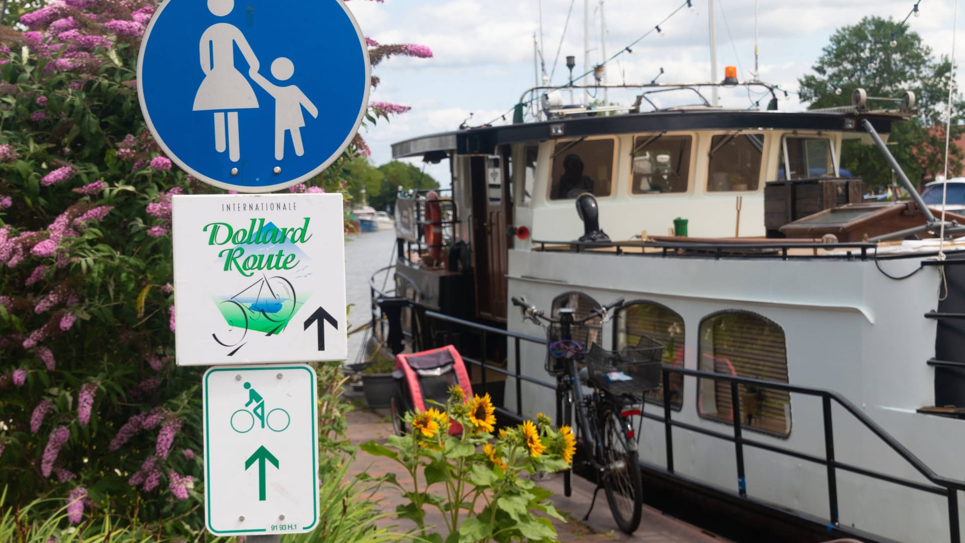 Der Fahrradweg Dollard Route geht an einem Schiff vorbei im historischen Hafen von Weener in Ostfriesland.