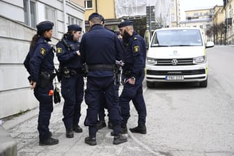 Schwedische Polizisten stehen zusammen (Symbolbild): Ein Straftäter ist auf dem Weg zum Zahnarzt von Maskierten befreit worden.