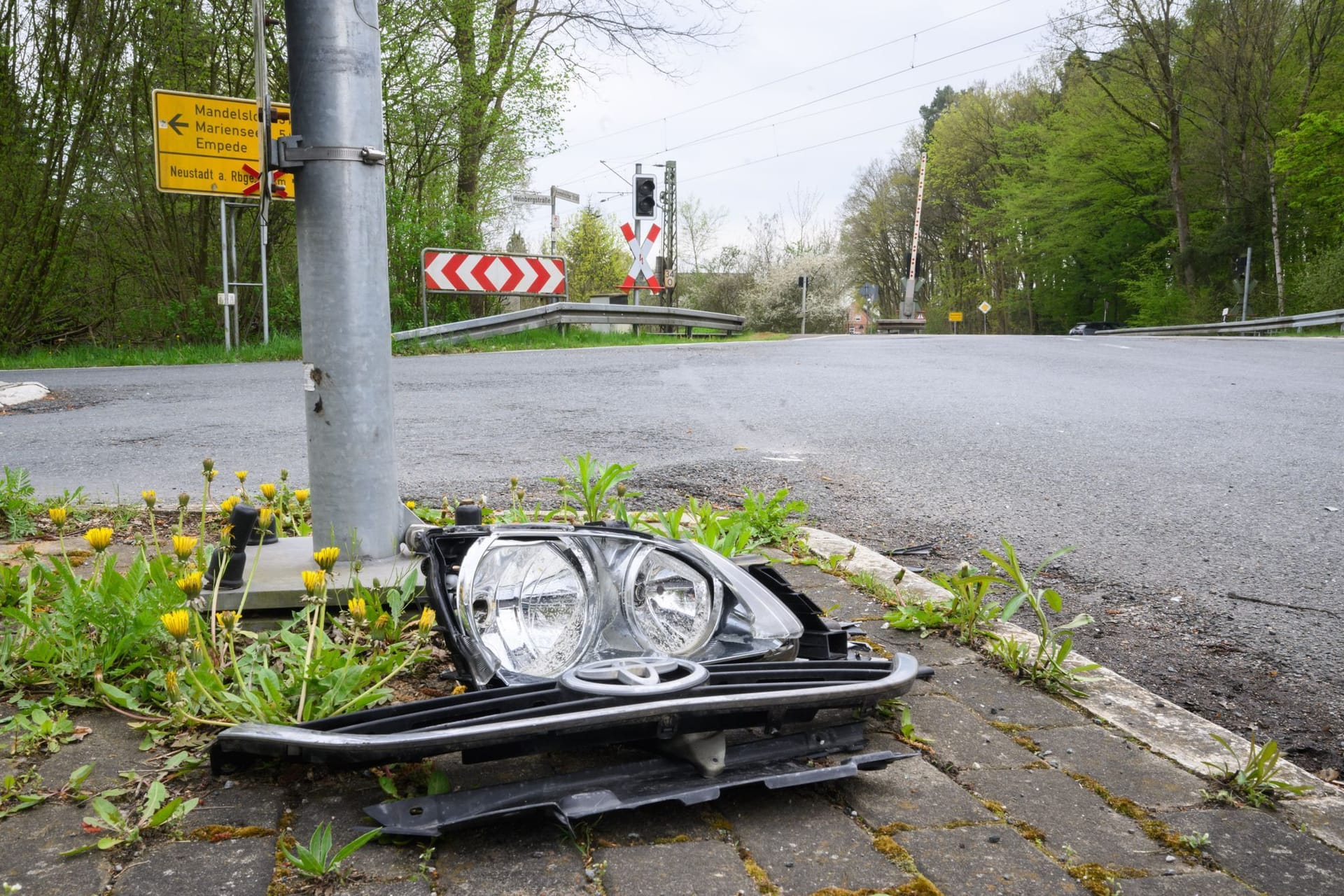 Trümmerteiles eines Pkw liegen am Bahnübergang, an dem am Sonntagmorgen ein Auto von einem Zug erfasst worden war: Drei Menschen starben, sie waren nach Polizeiangaben trotz geschlossener Halbschranken mit dem Auto auf den Bahnübergang gefahren.