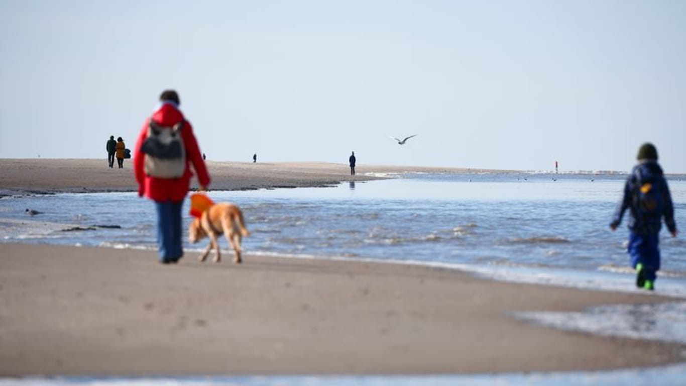 Strandgäste sind bei Sonnenschein und kühlem Wind am Nordseestrand unterwegs (Symbolbild): Für sie droht keine Gefahr.