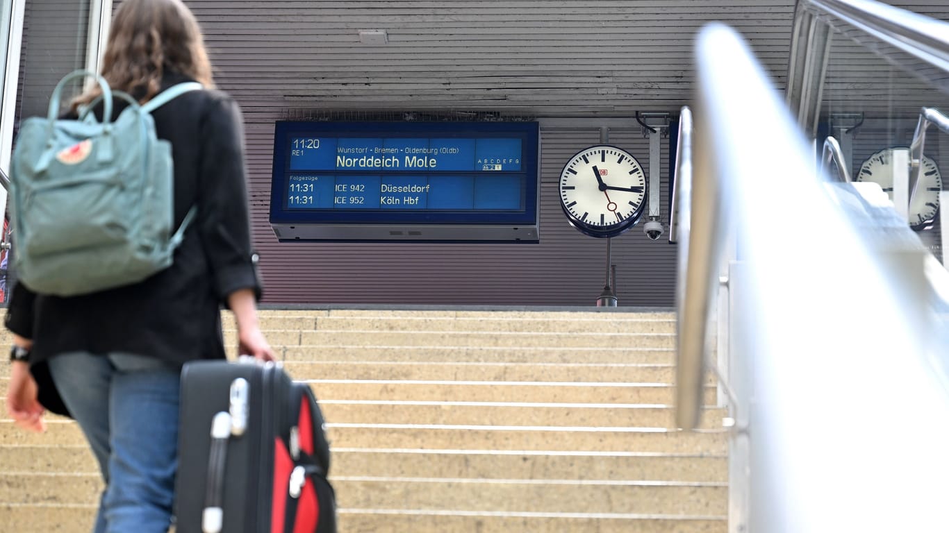 Eine Frau geht mit einem Koffer eine Treppe zum Bahnsteig nach Norddeich Mole hoch (Archivfoto): Bereits 2022 gab es Diskussionen um die Strecke.