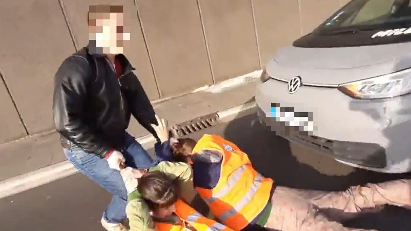 Attacke auf Aktivisten: Ein Mann zerrt zwei Klimaaktivisten von der A100 in Berlin.