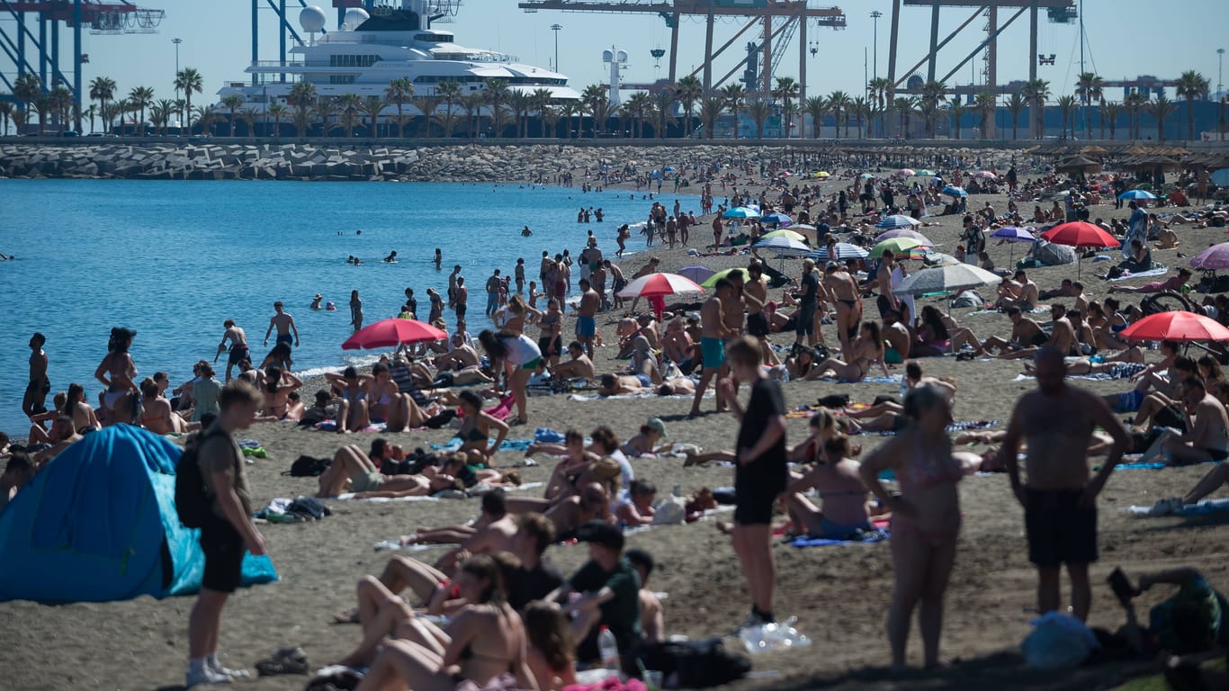 Menschen in Malaga entfliehen der Hitze am Strand: Die Regierung will Anpassungsmaßnahmen in diesem Jahr deutlich früher einführen als üblich.