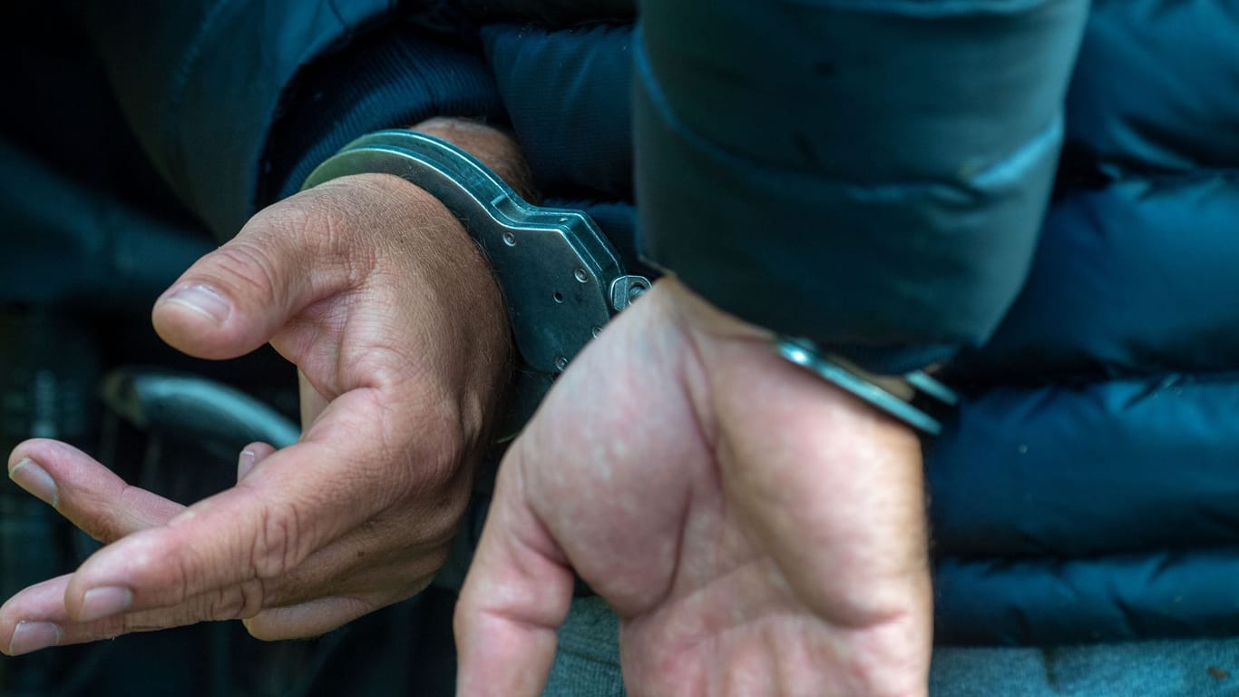 Ein Mann trägt Handschellen (Symbolbild): Drogenfahndern gelang ein Schlag gegen den internationalen Drogenhandel.