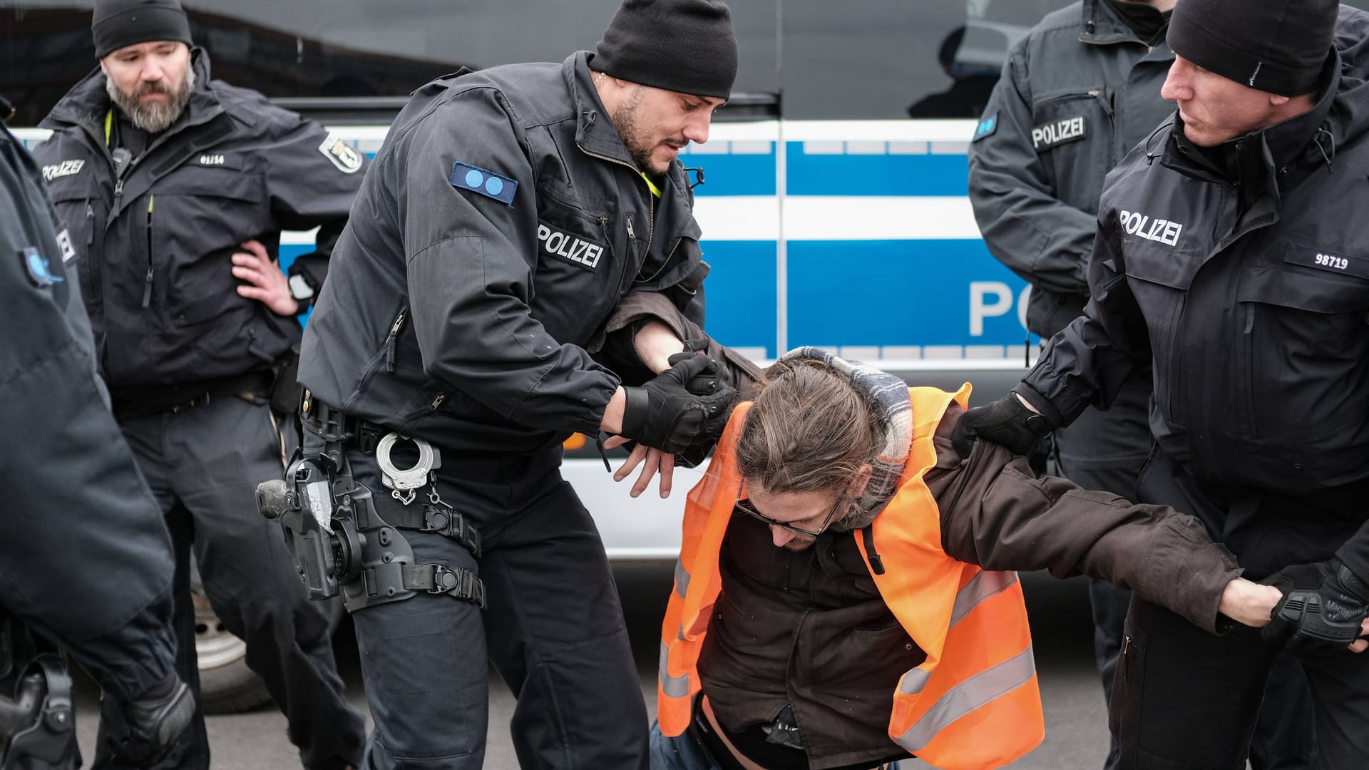 Polizisten tragen Klimaaktivisten weg (Symbolbild): Ein kursierendes Video zeigt Polizeigewalt – doch war sie gerechtfertigt?